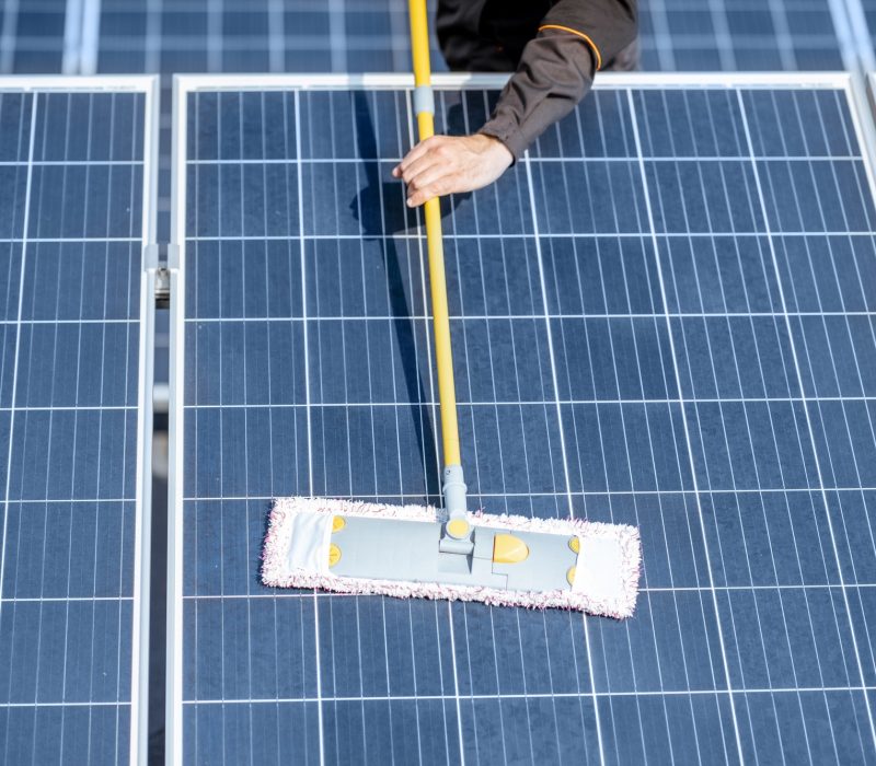 Workman cleaning solar panels